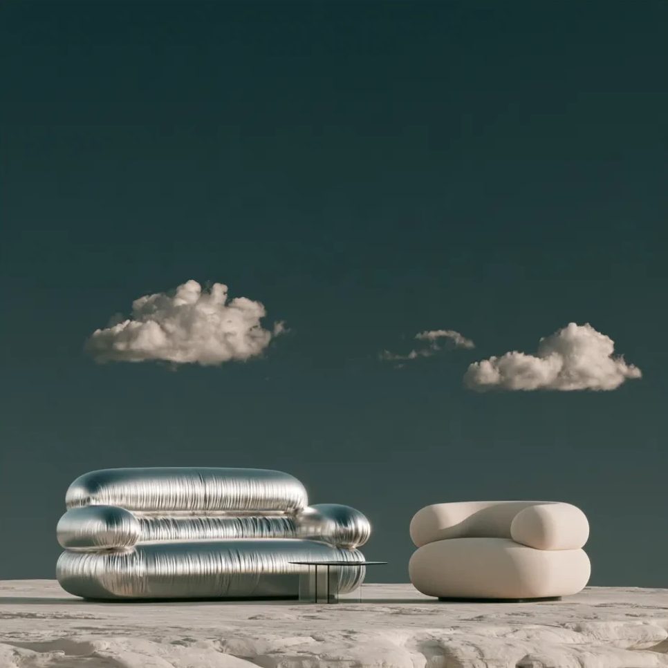 A silver sofa and an ivory armchair on a pale rock under a deep teal sky with soft clouds